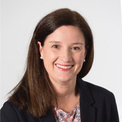 Smiling woman in a professional outfit.