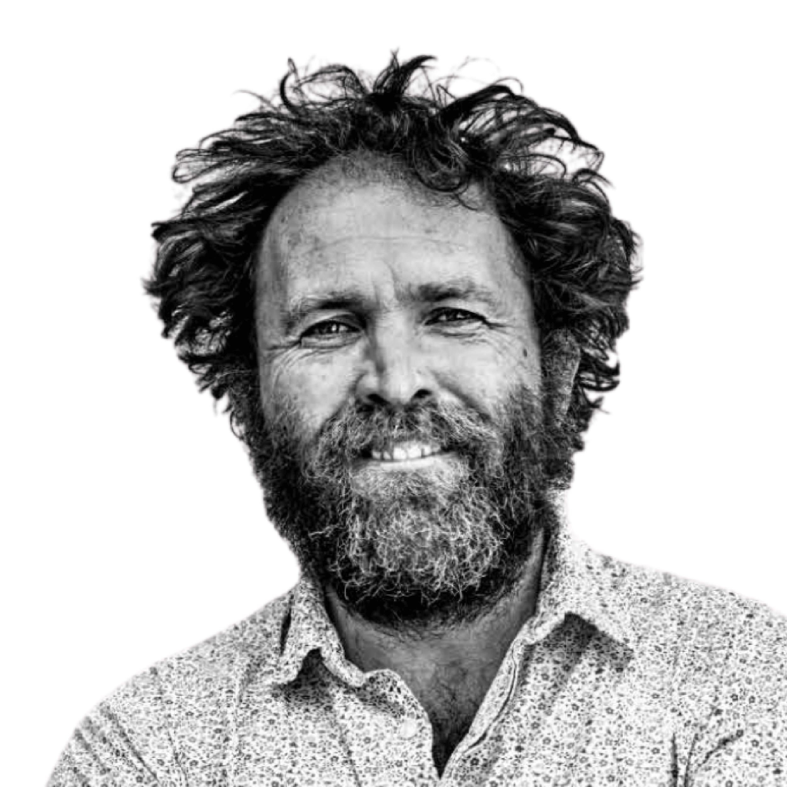 Grayscale portrait of a bearded smiling man.