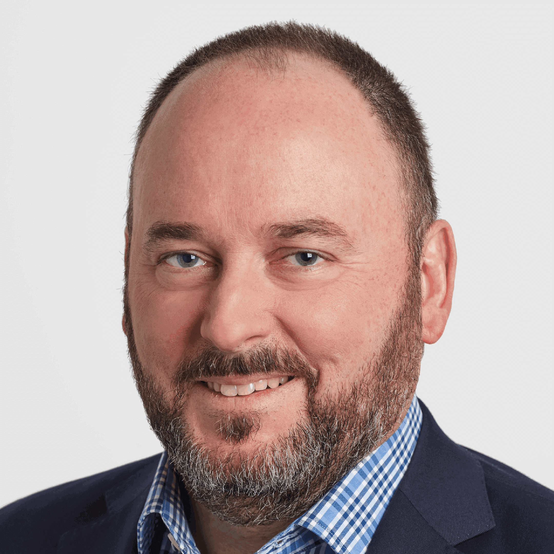 Man smiling in a suit and shirt.