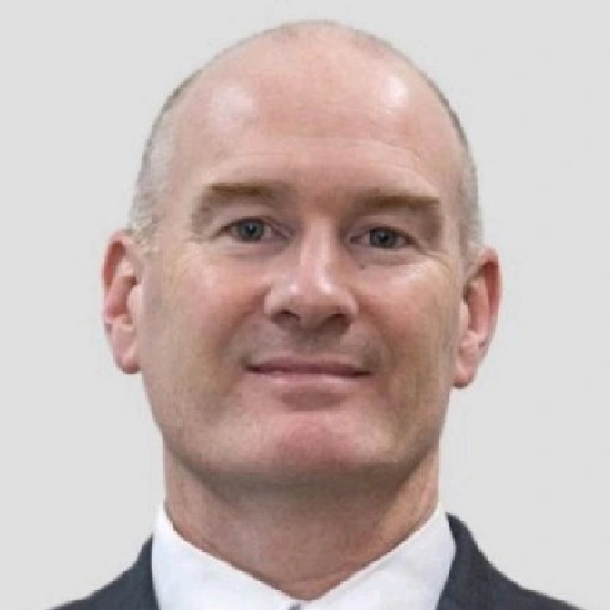 Man in suit with neutral expression.