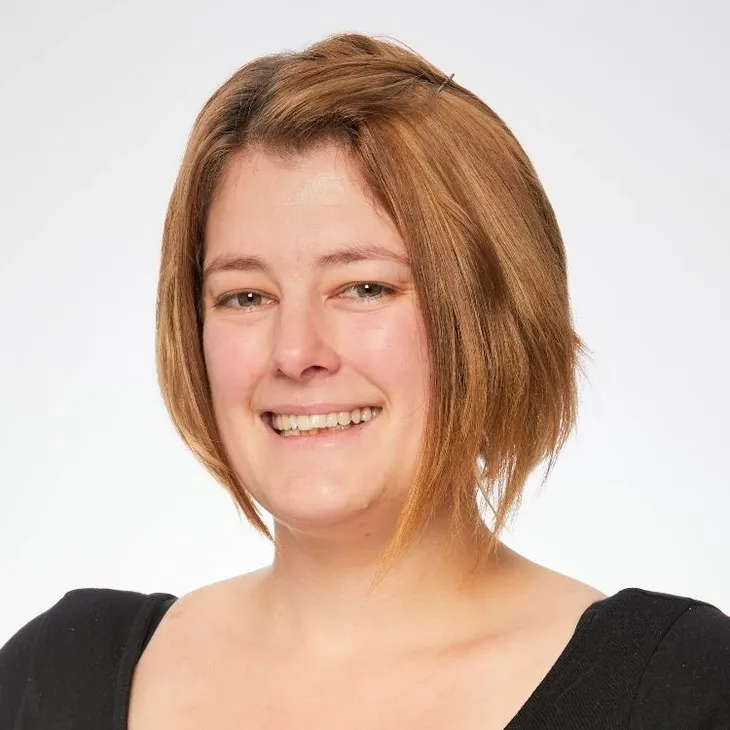 Smiling person with short, light brown hair.