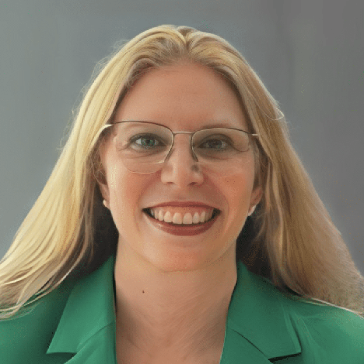 Smiling person with glasses and green jacket.