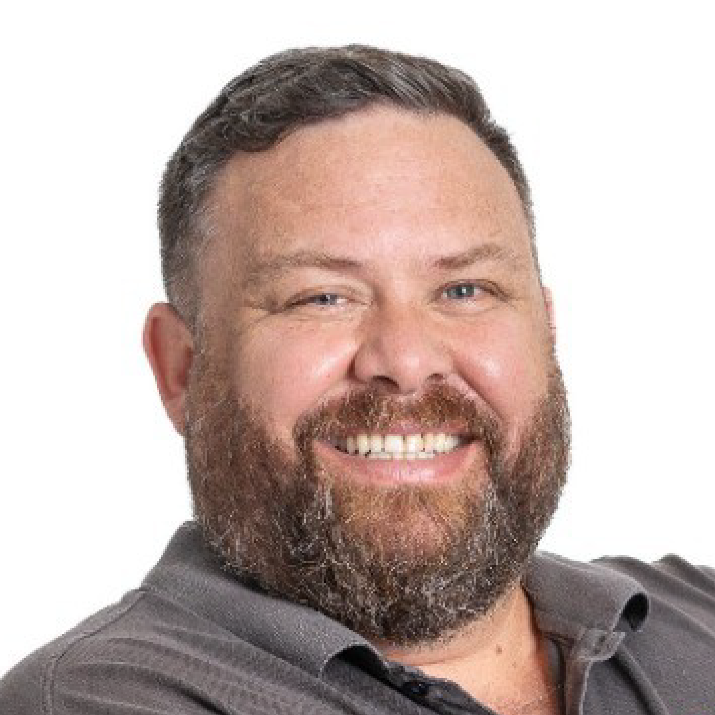 Smiling man with a beard and shirt.