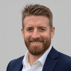 Smiling man in a suit jacket.